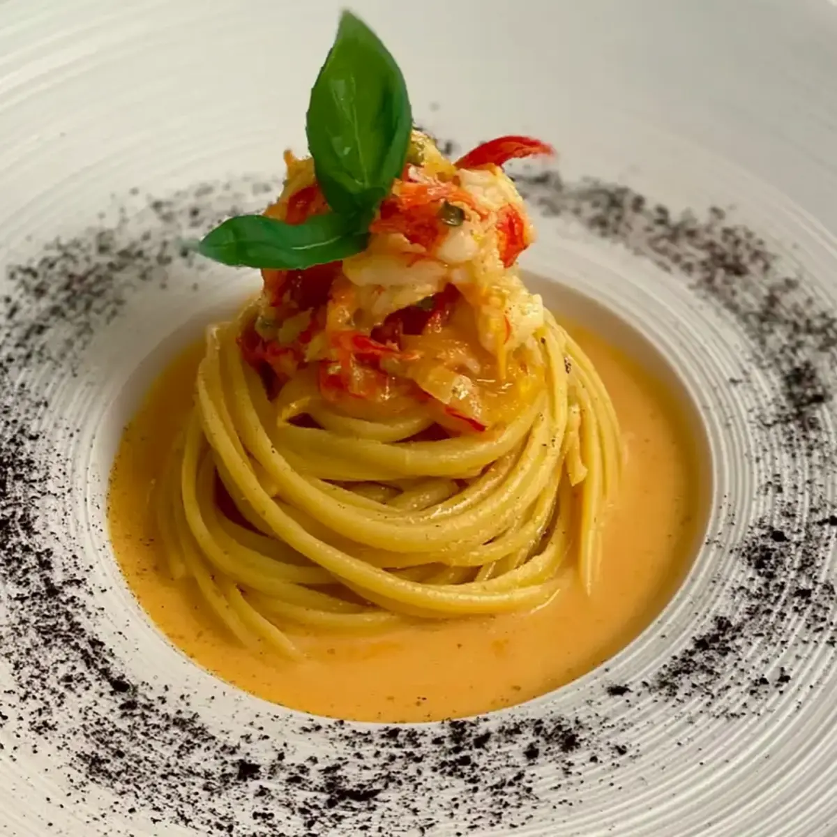 Linguine agli agrumi con gamberi rosa, bisque e polvere di liquirizia